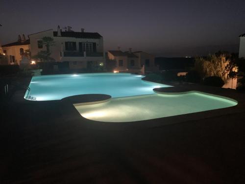 a swimming pool lit up at night at Apartamento con preciosa vista al mar y AA in Son Parc