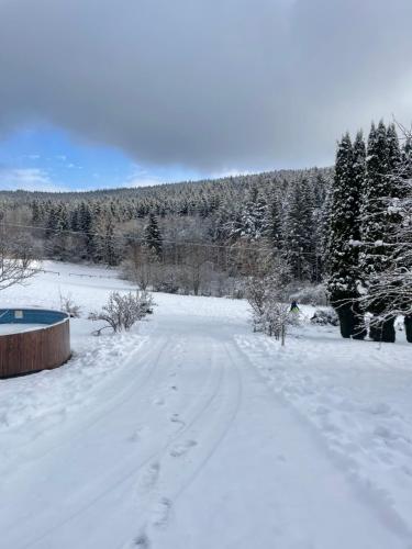 a snow covered field with footprints in the snow at Chata Monika in Frymburk