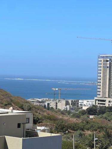 a view of a city with the ocean and buildings at Jumeirah on the hills, Mamelles in Dakar