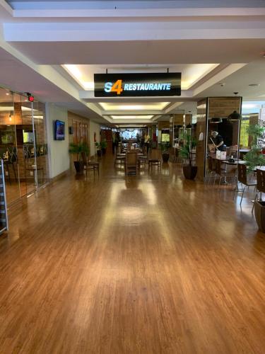 a lobby with a hard wood floor and a restaurant at FLAT 1417 in Águas Claras