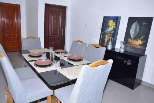 a dining room with a black table and white chairs at Jumeirah on the hills, Mamelles in Dakar
