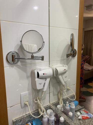 a bathroom with two hair dryers and a mirror at FLAT 1417 in Águas Claras