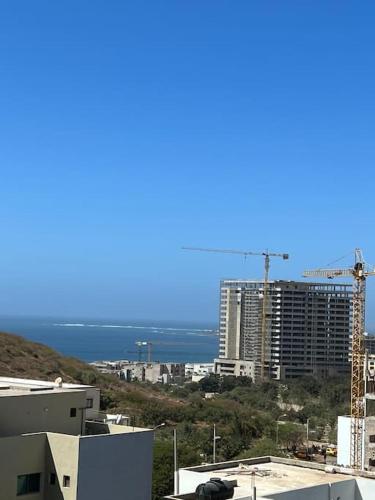 a view of a city with a crane and buildings at Jumeirah on the hills, Mamelles in Dakar