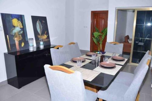 a dining room with a black table and white chairs at Jumeirah on the hills, Mamelles in Dakar