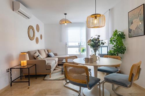 uma sala de estar com um sofá, uma mesa e cadeiras em Teatro Suites Málaga CITY FLAT em Málaga