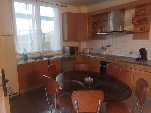 une cuisine avec une table et des chaises dans l'établissement comme a la maison, à Rousson