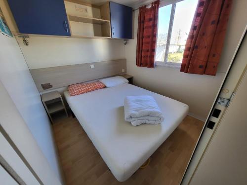 a small room with a white bed with a window at Campeggio Don Bosco in Lido di Jesolo