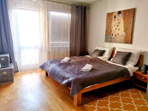 1 dormitorio con 1 cama con 2 toallas en CozyHome Retro Apartment, en Bratislava