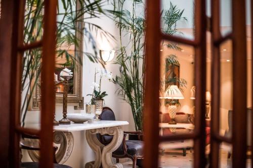 a table and chairs in a room with plants at Los Tallanes Hotel & Suites in Lima