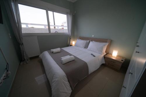 una camera da letto con un grande letto con due asciugamani di EMVI APARTMENTS II near airport a Braurone