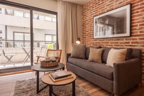 sala de estar con sofá y pared de ladrillo en Cozy & Modern Luxe Apartment -La Galerie San Telmo- 228 en Buenos Aires