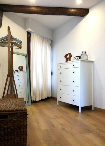 a bedroom with a white dresser and a mirror at Portubide Bermeo in Bermeo