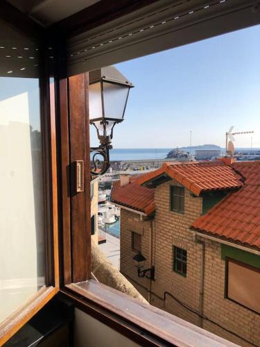 a window with a view of a building at Portubide Bermeo in Bermeo