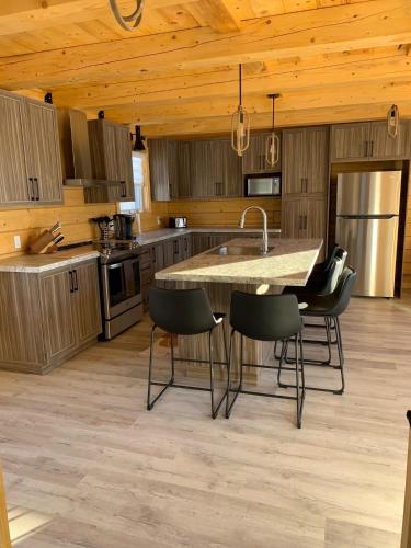 a kitchen with a table and chairs in a room at Chalets domaine Otis in Saint-Félix-d'Otis