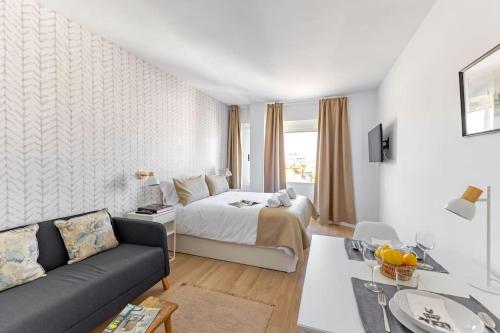 a hotel room with a bed and a couch at NEW Suite reformada con excelente ubicación in Seville