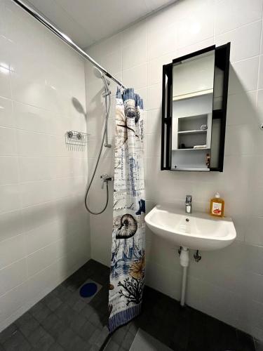 y baño con lavabo y ducha con espejo. en Savi Apartment 3 en Pärnu