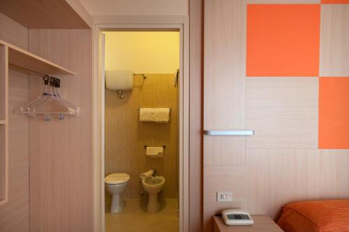 ein kleines Bad mit WC und ein Bett in der Unterkunft Hotel Regent in Pescara