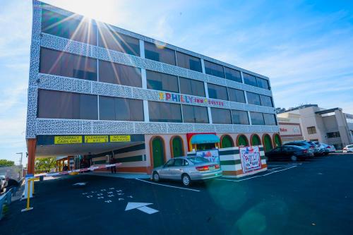 a building with a car parked in a parking lot at Philly Inn & Suites in Philadelphia