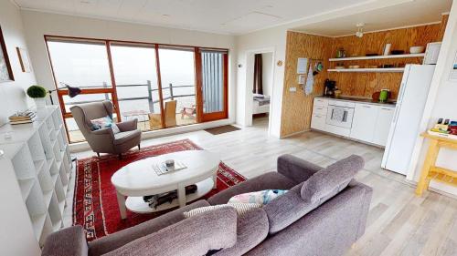 a living room with a couch and a table at Gotuhus - Sea View Apartment in Hellissandur