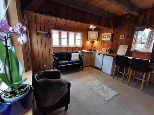 a kitchen and living room with a couch and chairs at Birkevang The Silo - Rural refuge in Faxe