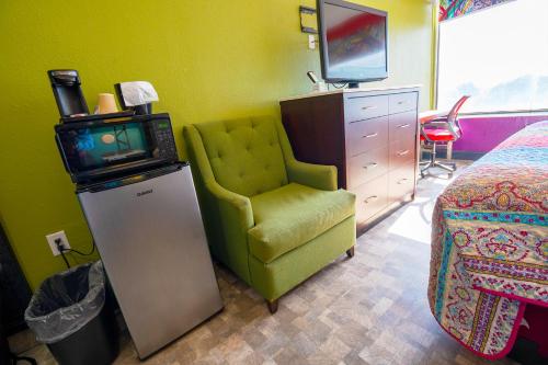 a room with a tv and a chair and a bed at Philly Inn & Suites in Philadelphia