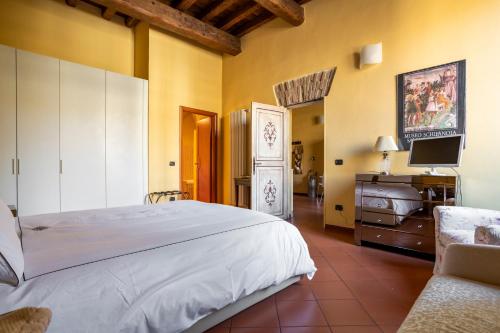 1 dormitorio con 1 cama blanca grande y TV en CASA DUCHESSE al Castello, en Ferrara