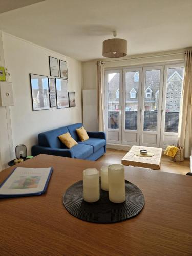 un salon avec un canapé bleu et une table dans l'établissement Le Portel Plage les 4 saisons 2, à Le Portel