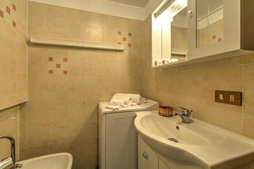 a bathroom with a sink and a toilet and a mirror at APPARTAMENTO CLAIRE - Relax con splendida vista - COUR 0081 in Courmayeur