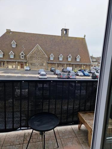 une chaise noire assise sur un balcon avec un parking dans l'établissement Le Portel Plage les 4 saisons 2, à Le Portel