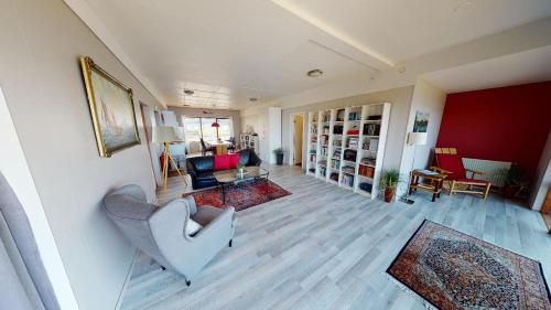 a living room with a couch and a chair at Kleifar: Ocean View Apartment in Hellissandur