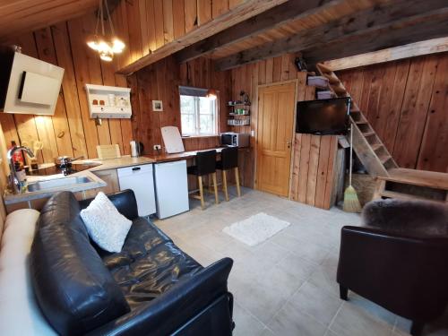 ein Wohnzimmer mit einem Sofa und einer Küche in der Unterkunft Birkevang The Silo - Rural refuge in Faxe