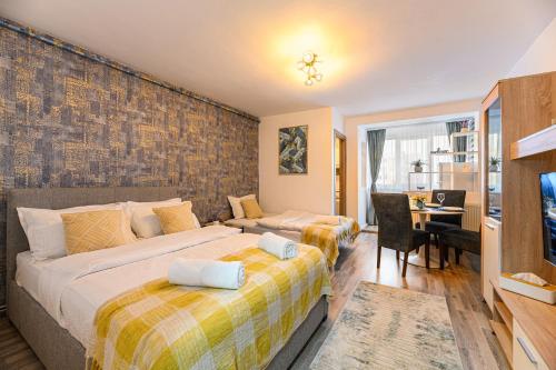 1 dormitorio con 2 camas y escritorio con escritorio en JAD - Luxury Studio - Soarelui 10, en Brasov