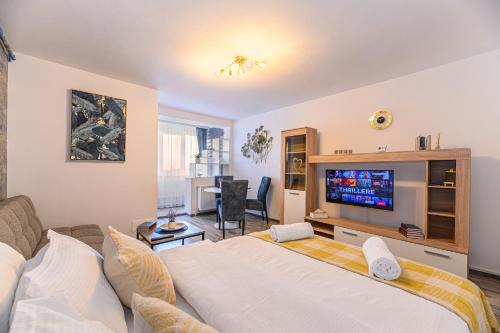 a living room with a large bed and a television at JAD - Luxury Studio - Soarelui 10 in Braşov
