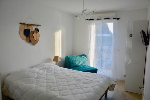 ein Schlafzimmer mit einem Bett und einem blauen Stuhl in der Unterkunft TY DOLMEN DU Plages à pied 2 vélos WIFI in Carnac