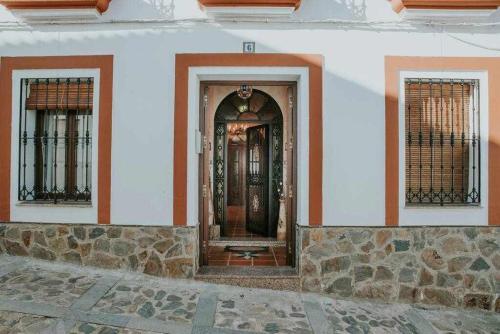 une porte d'entrée d'une maison avec deux fenêtres dans l'établissement Casa rural con jacuzzi, sauna, barbacoa y barra, à Cabeza la Vaca