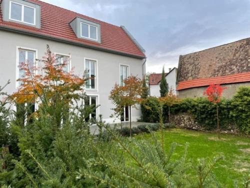 a white house with a red roof and a yard at Wohnen am Seebach in Westhofen