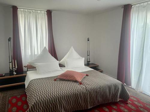 1 dormitorio con 1 cama grande con almohadas blancas en Wohnen am Seebach en Westhofen