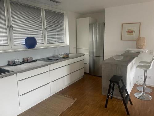 a kitchen with white cabinets and a stainless steel refrigerator at Wohnen am Seebach in Westhofen
