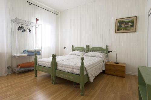 a bedroom with a green bed and a wooden floor at Casa Sincielli in Caorle