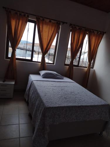 a bedroom with a bed and two windows at Hotel Lili Popayán - Sede 2 in Popayan