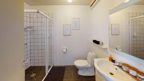 a bathroom with a shower and a toilet and a sink at Brenna: Cliffside Apartment in Hellissandur