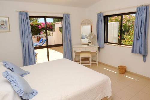 a bedroom with a bed and a desk with a mirror at Vivenda Cinquenta e Sete in Poço Partido