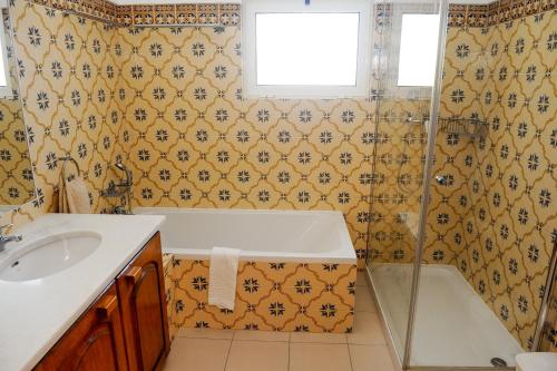 a bathroom with a tub and a sink at Vivenda Cinquenta e Sete in Poço Partido