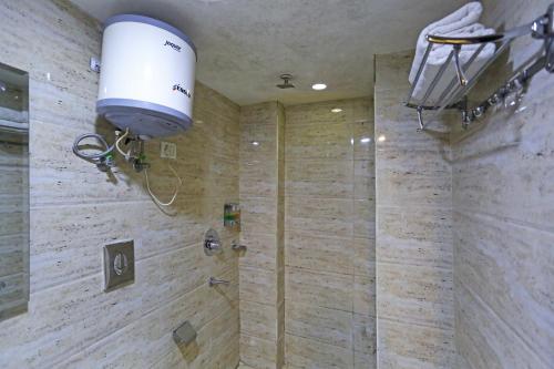 a bathroom with a shower with a light on the wall at Hotel Grand Suites By D'Capitol Near IGI Airport in New Delhi