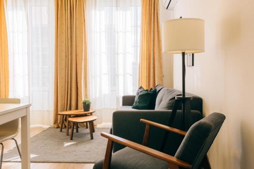 - un salon avec un canapé vert et une chaise dans l'établissement ORM Catedral & São Bento & Luiz Apartments, à Porto