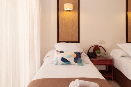 a bedroom with a bed with a pillow on it at Hotel Eden Mar in Guardamar del Segura