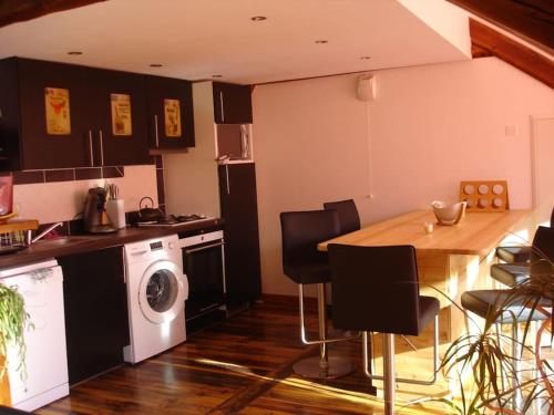 une cuisine avec une table et une machine à laver dans l'établissement Appart T3 de charme sous les toits Jausiers 6 pers, à Jausiers