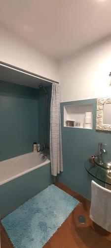 a bathroom with a bath tub and a rug at Upstairs Home in Ponta Delgada