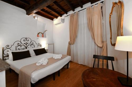 1 dormitorio con 1 cama y 1 mesa con lámpara en Residenze Romanae - Sangallo Rooms, en Roma