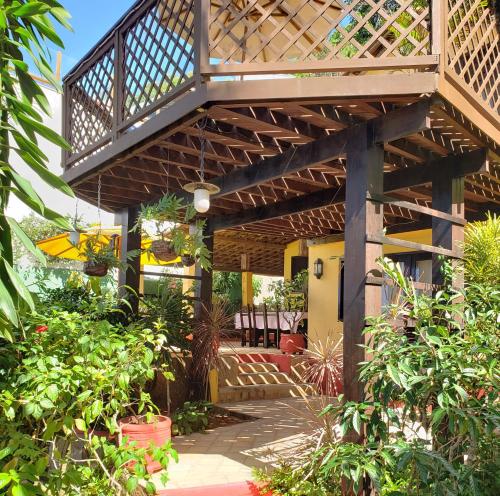 a patio with a wooden pergola in a garden at Casa Serena in Pipa